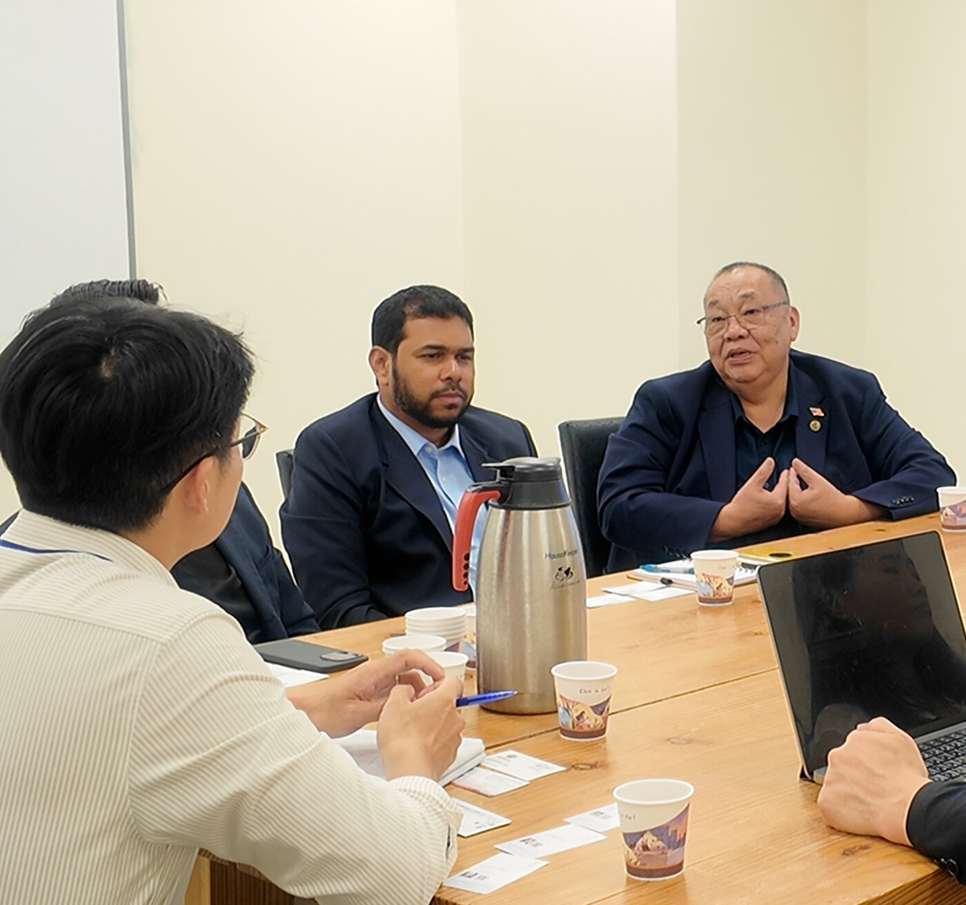 ACE Biotek の会議室で資料を挟んで話し合う様子